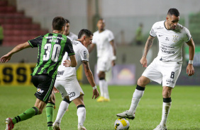 Renato Augusto com a bola dominada no jogo entre Corinthians e Amrica-MG; Vital aparece na foto